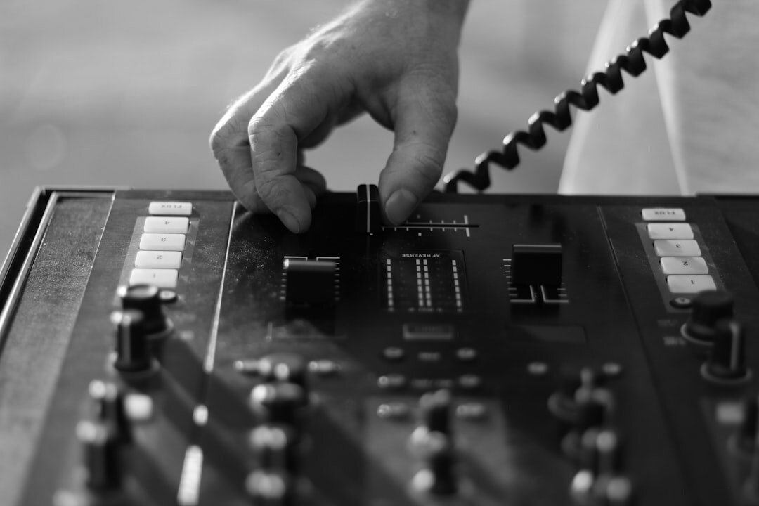 Close up of hands adjusting audio mixing console sliders